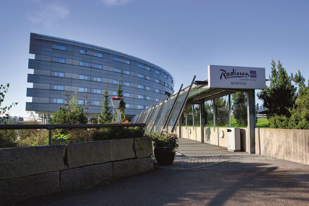 Oversiktsbilde av inngangen til Radisson Blue hotellet på Oslo lufthavn hvor man ser hotellet i bakgrunnen